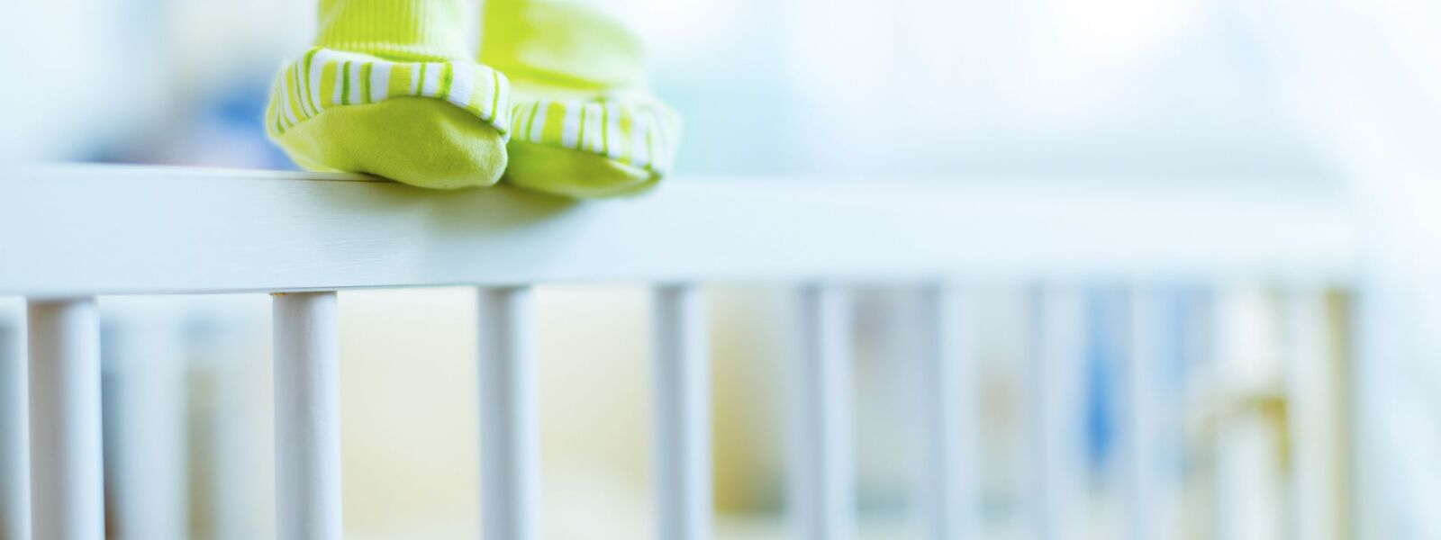 Baby shoes on the edge of a cot (Demo) Baby shoes on the edge of a cot.